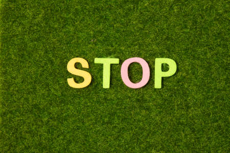 On a black background, bright multicolored stickers with the word STOP. Illustrationの写真素材