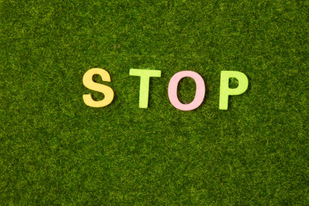 On a black background, bright multicolored stickers with the word STOP. Illustrationの写真素材