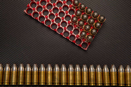 War concept. Bullets and shells in the hands of a child, against the background of money coins