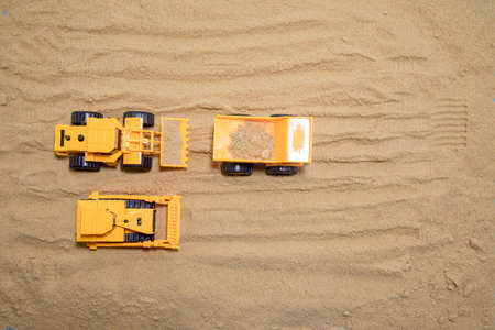 Big excavator is filling a dumper truck with soil at construction site, project in progress.の写真素材