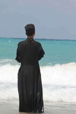 Orthodox priest in front of blue Seaの写真素材