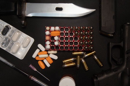 Hand gun on black background, bullets and handcuffs. 9mm pistol with ammunition on dark table.の写真素材