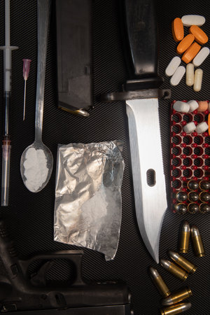 Hand gun on black background, bullets and handcuffs. 9mm pistol with ammunition on dark table. High quality photoの写真素材