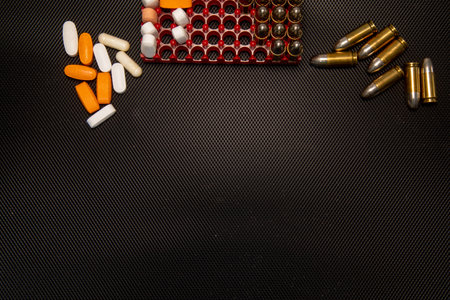 Hand gun on black background, bullets and handcuffs. 9mm pistol with ammunition on dark table. High quality photoの写真素材