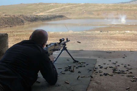 A soldier fires a machine gun High quality