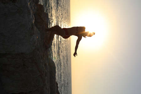 Silhouette of a woman and man dancing against a sea backgroundの写真素材