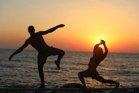 Silhouette of a woman dancing against a sea backgroundの写真素材