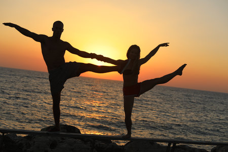Silhouette of a woman dancing against a sea backgroundの写真素材