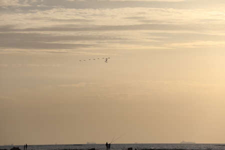 Sunset and sun lights comes between clouds to oceanの写真素材