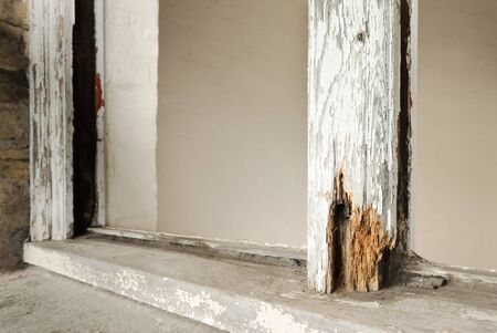 Close up of rotten sash window frame against white background. Sash window restoration.