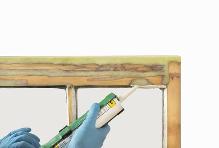 Close up of a person applying dry seal to restored sash windows. Sash window restoration.の写真素材