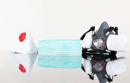 Selection of different type of face masks laid on the glass surface.