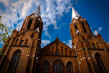 Catholic church towers surrounded by blue cloudy skyの写真素材