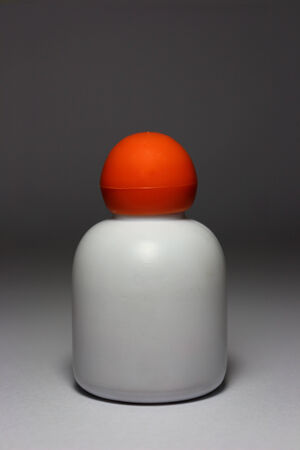 Small white opaque bottle in dark backgroundの写真素材