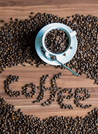 A still life of coffee beans and a cup.