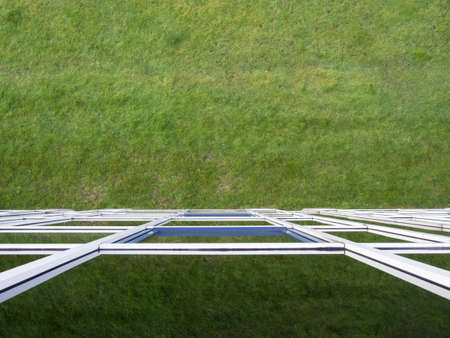 Mirrored glass building. Grass is reflected in the windowsの写真素材