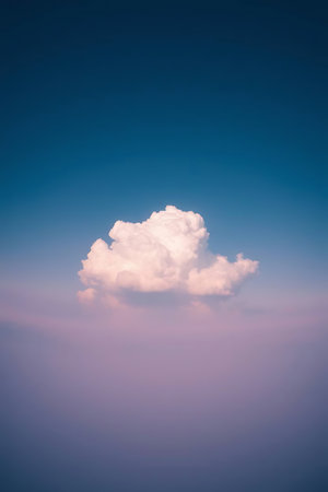 A single, fluffy cloud drifts gracefully against a gradient sky, exuding peace and tranquility. Ideal for projects needing a sense of calm or a touch of dreamy beauty, evoking feelings of freedom and serenity.の素材