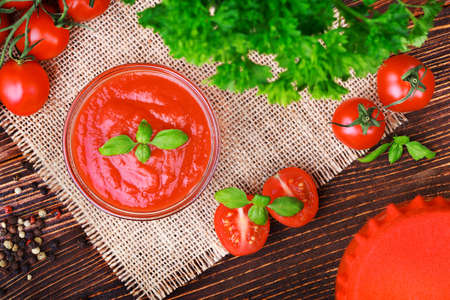 Tomatoes paste and ripe tomatoes on an old brown wooden table(selective focus).の写真素材