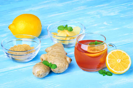 Ginger tea with mint and lemon on blue wooden table(selective focus).