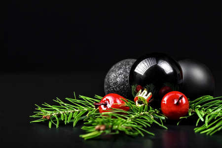 Christmas ornaments with pine tree branches on a black backgroundの写真素材