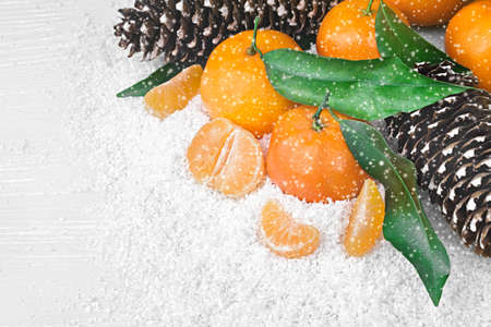 Fresh clementines in snow on an old gray wooden table, top view.の写真素材