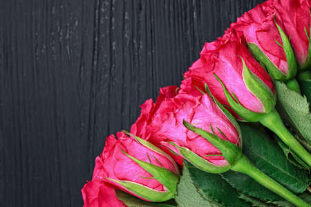 Beautiful pink rose bouquet on a black wooden table, top view (selective focus).の写真素材