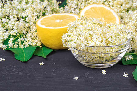Elderflower on black wooden table, top view (selective focus)の写真素材