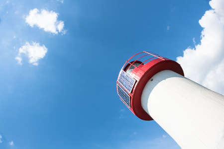 Lighthouse Photovoltaic Sky . Sea Mark at the harbor with blue sky with clouds in backgroundの写真素材