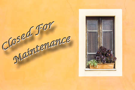 Closed window with planter  and yellow wall with written "closed For Maintenance"の写真素材