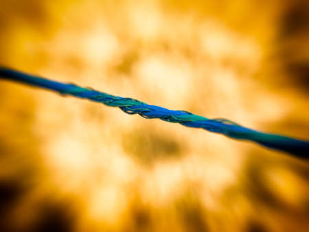 tightrope blue. Close up image of a cord iwith fire effect in background. Concept of hanging by a...