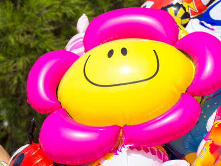 The sun in the face. Image of a flower smiley baloon that look and follow the sunの写真素材