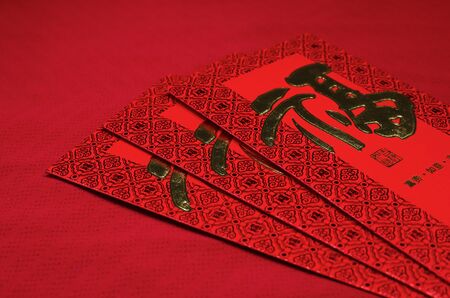 Red envelope in Chinese new year festival on red background, Chinese character means wealth.の写真素材