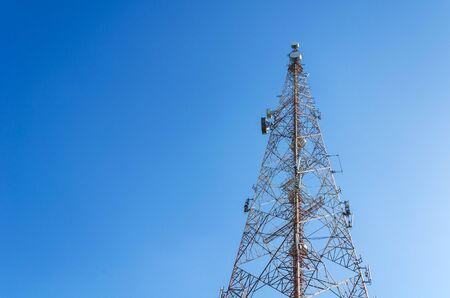Telecommunication tower for used to transmit telephone or television signal with blue sky.