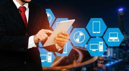 smart businessman in suit using his tablet with social media icon business and technology concept on...