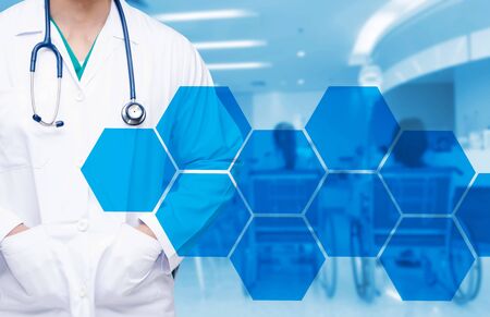 smart doctor with a stethoscope around his neck on the hospital blurred and hexagon shaped pattern design background, healthcare medical technology concept, copy space.の写真素材