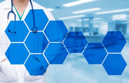 smart doctor with a stethoscope around his neck on the hospital blurred and hexagon shaped pattern design background, healthcare medical technology concept, copy space.の写真素材