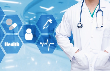 smart doctor with a stethoscope around his neck on the hospital blurred and health care and icon in hexagona shaped pattern background, health care and medical technology conceptの写真素材