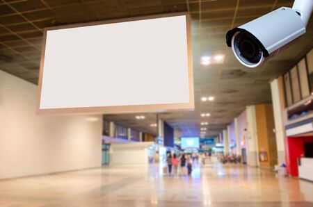 security CCTV camera with blank billboard with empty copy space in the airport for new advertisement with blurred interior airport background.の写真素材