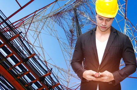 smart construction manager in suite with walkie-talkie or two way radio in hand and yellow safety...