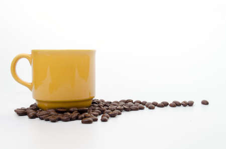 coffee beans and  yellow coffee cup isolated on white backgroundの写真素材