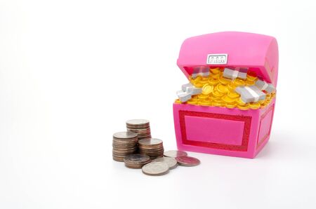 Piggy bank or Treasure Chest shaped money box with coins on white background, in saving money concept, copy spaceの写真素材