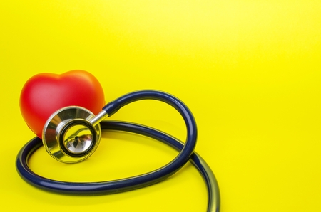 red heart and stethoscope on yellow background, heart health care and medical technology concept, selective focus, copy spaceの写真素材