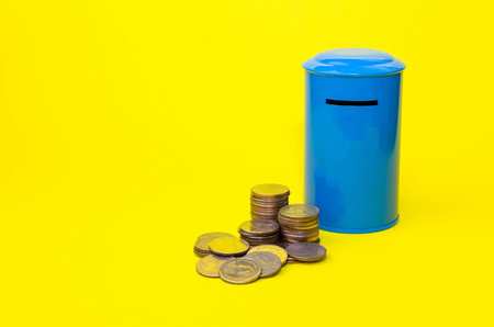 piggy bank or vintage retro blue post box shaped money box with money coin stack on yellow background, financial, business, saving money concept, selective focusの写真素材