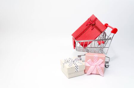mini supermarket shopping cart with mini colorful gift box on white background, holiday sale and online shopping concept, selective focus, copy spaceの写真素材