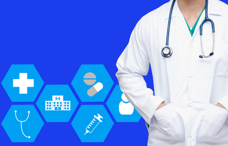 smart doctor with a stethoscope around his neck on blue color background and health care icon in hexagonal shaped pattern background, health care and medical technology conceptの写真素材