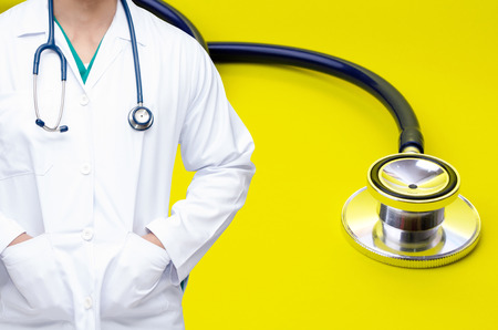 smart doctor with a stethoscope around his neck with stethoscope on yellow background, heart health care and medical technology concept, selective focus, copy spaceの写真素材