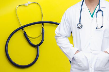 smart doctor with a stethoscope around his neck with stethoscope on yellow background, heart health care and medical technology concept, selective focus, copy spaceの写真素材