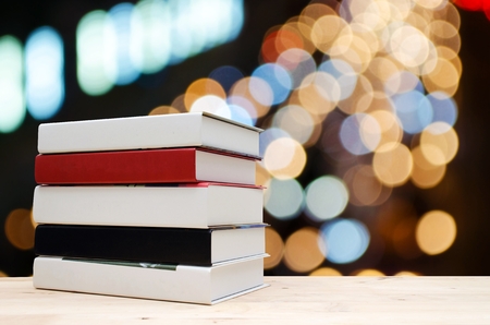 stack book on desk, no labels, blank spine with blurred night light bokeh background, selective focus, education back to school and business concept, color tone effect, copy spaceの写真素材