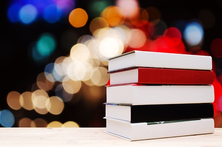 stack book on desk, no labels, blank spine with blurred night light bokeh background, selective focus, education back to school and business concept, vintage color tone effect, copy spaceの写真素材