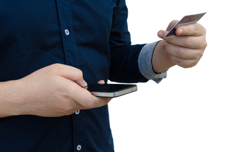 young man holding credit card and using smartphone isolated on white background, online shopping, online payment, lifestyle technology, finances and economy concept, soft focus, selective focusの写真素材